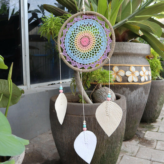 multicolour dream catcher hanging in a garden